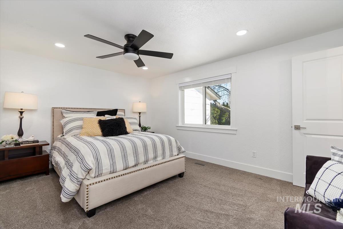 Carpeted bedroom featuring ceiling fan and recessed lighting