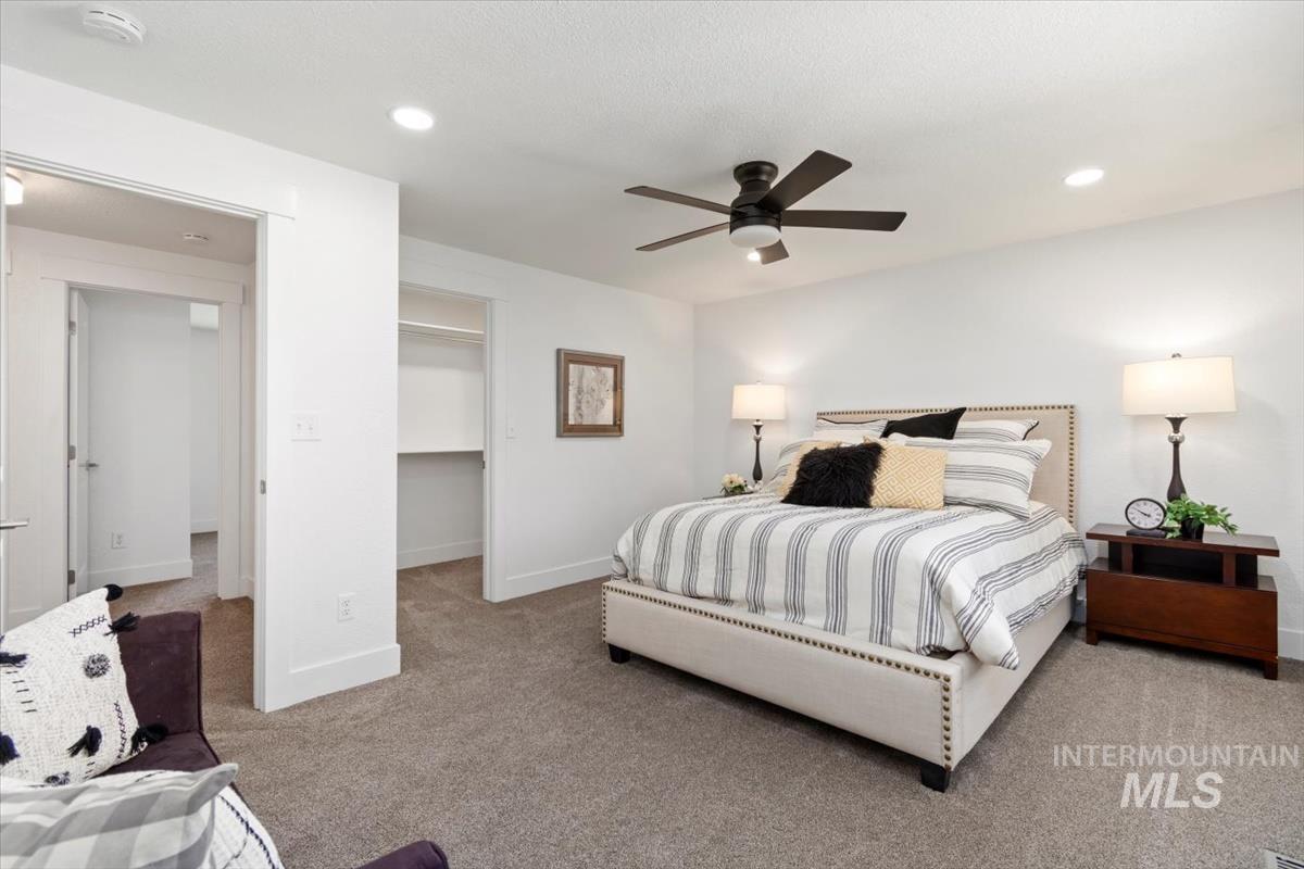 Carpeted bedroom with recessed lighting, a ceiling fan, and a spacious closet