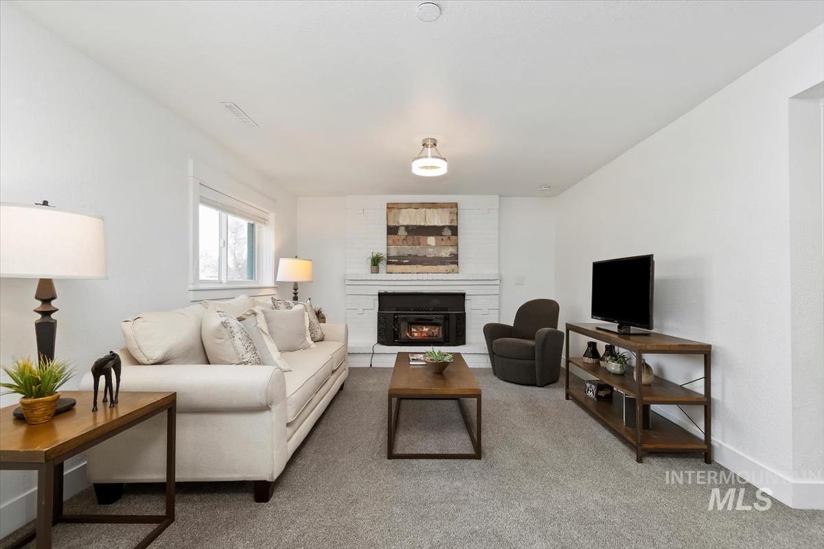 Living area featuring light colored carpet and a large fireplace