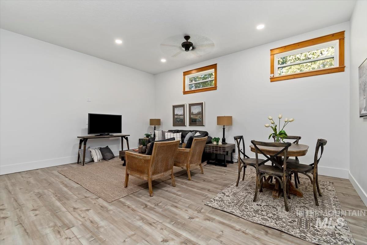Living room featuring a ceiling fan, light wood-style floors, and recessed lighting