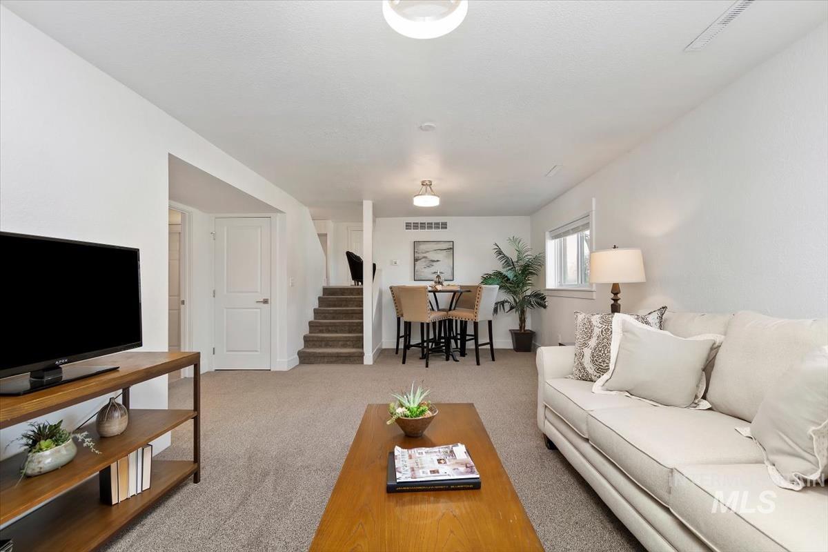 Carpeted living area featuring stairway