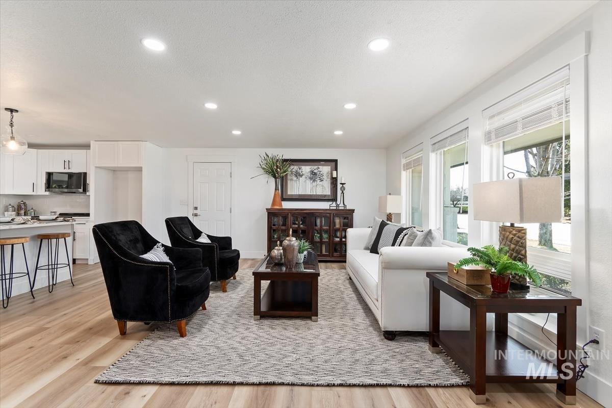 Living area with light wood-style floors and recessed lighting