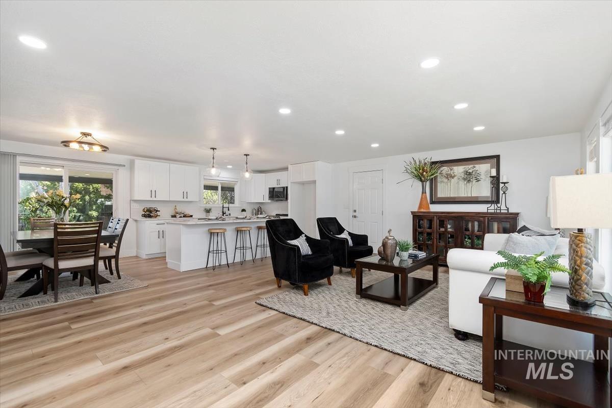 Living room with light wood-style flooring and recessed lighting