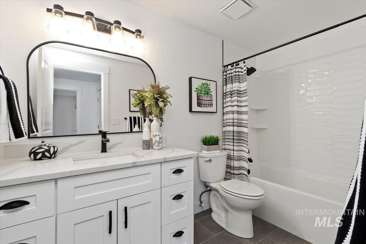 Full bathroom featuring vanity, tile patterned flooring, and shower / bath combo
