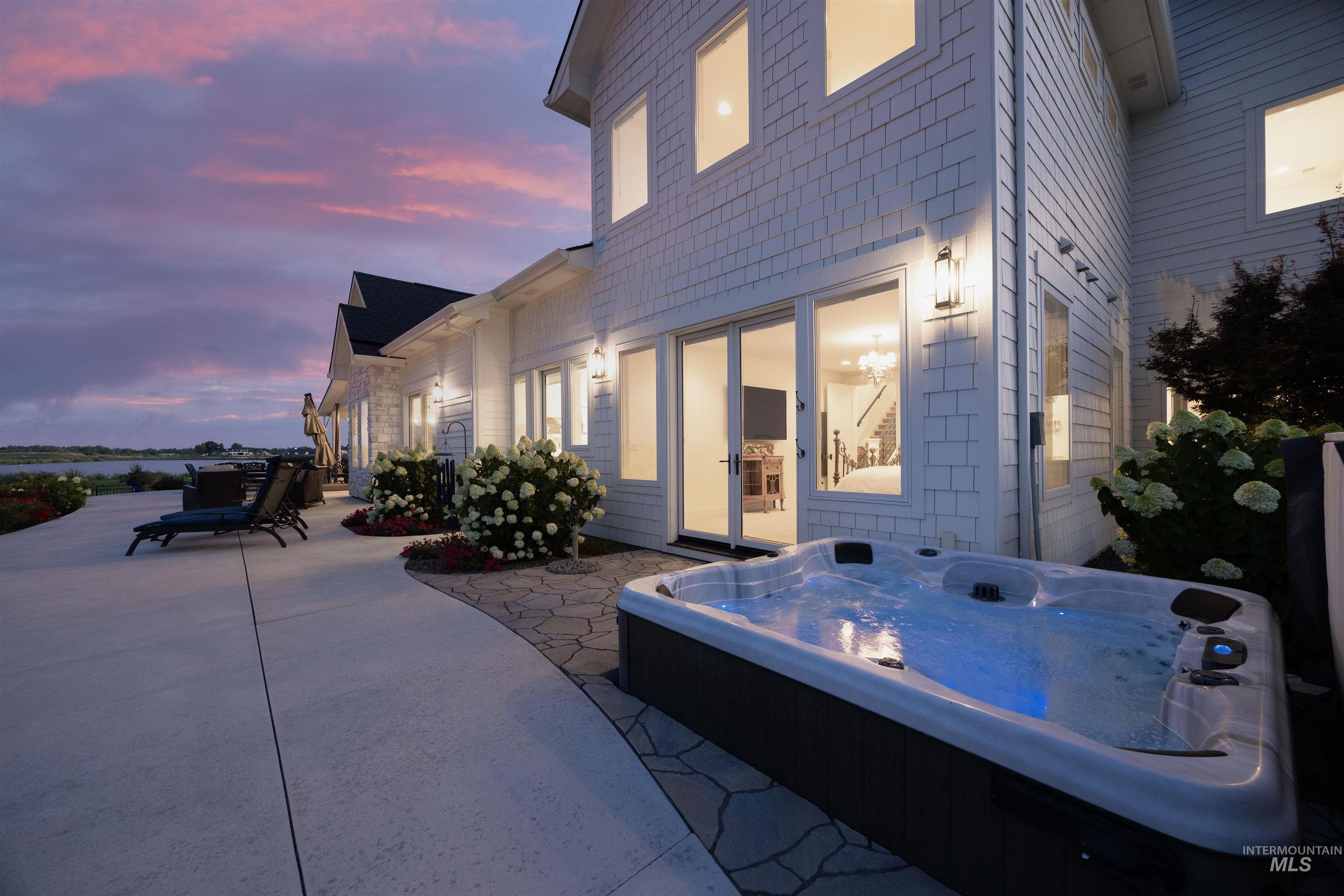 Patio terrace at dusk featuring a hot tub and a patio
