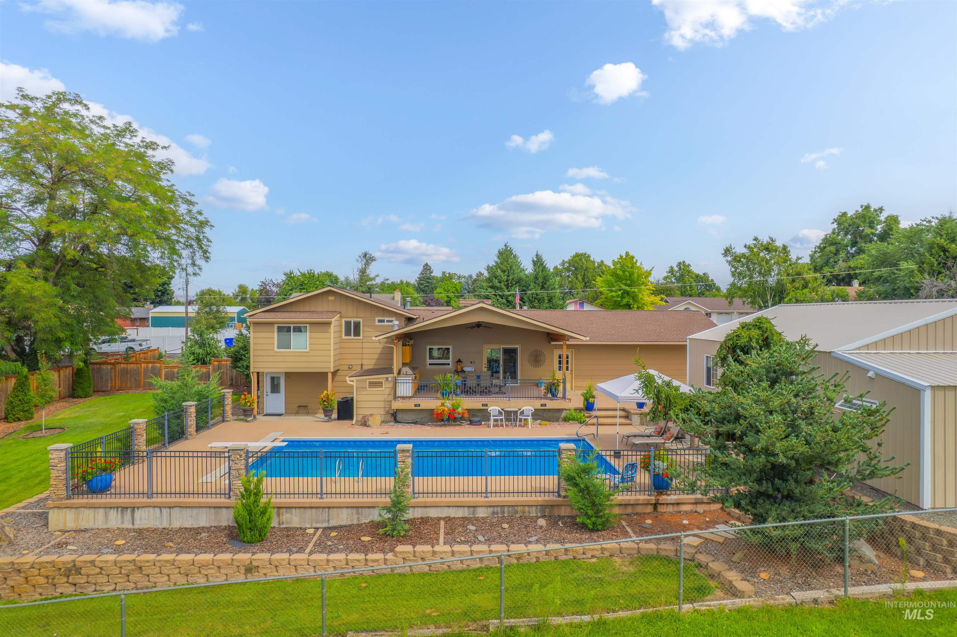 View of swimming pool featuring a patio, a fenced backyard, and a diving board