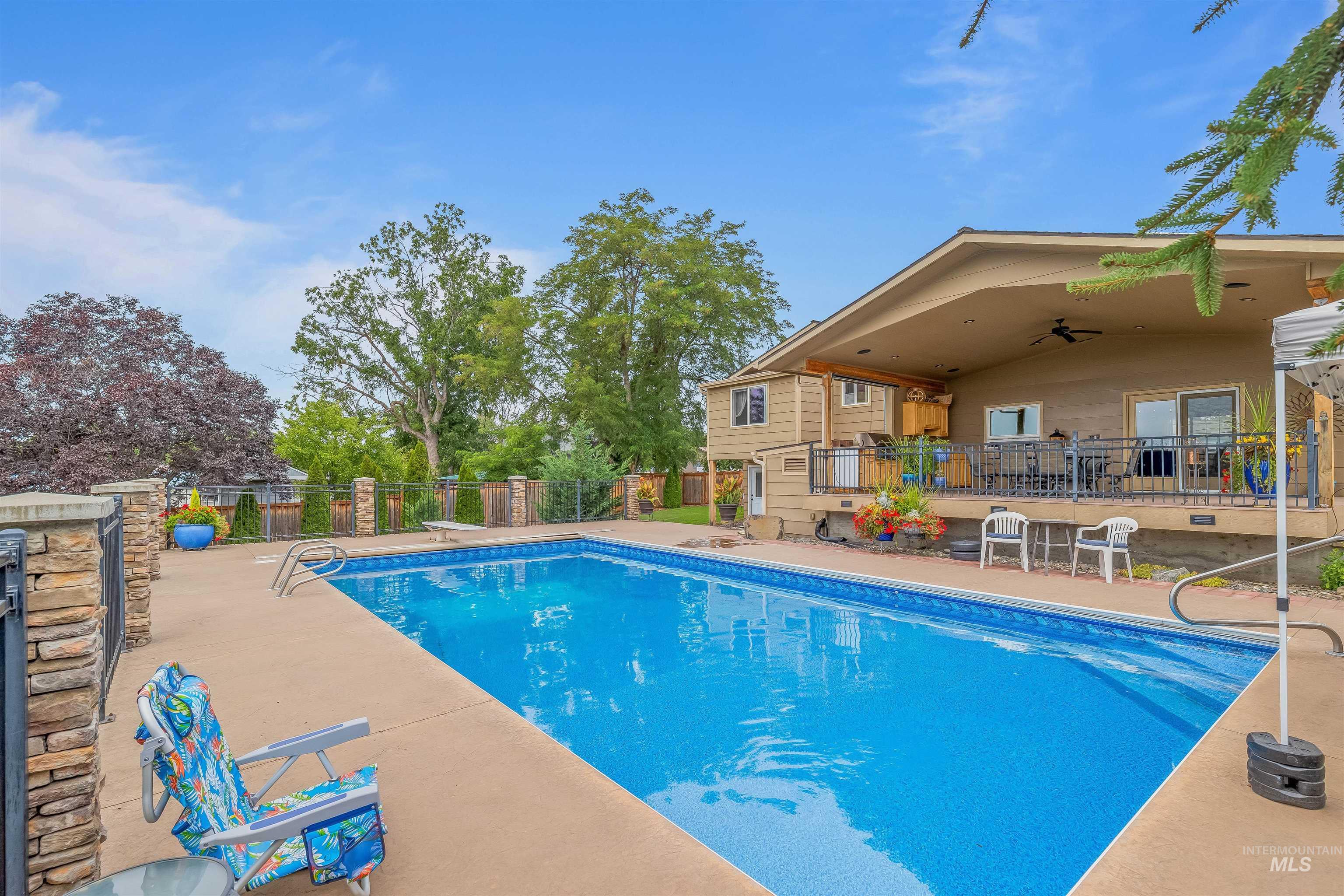 View of pool featuring a patio, ceiling fan, and a diving board