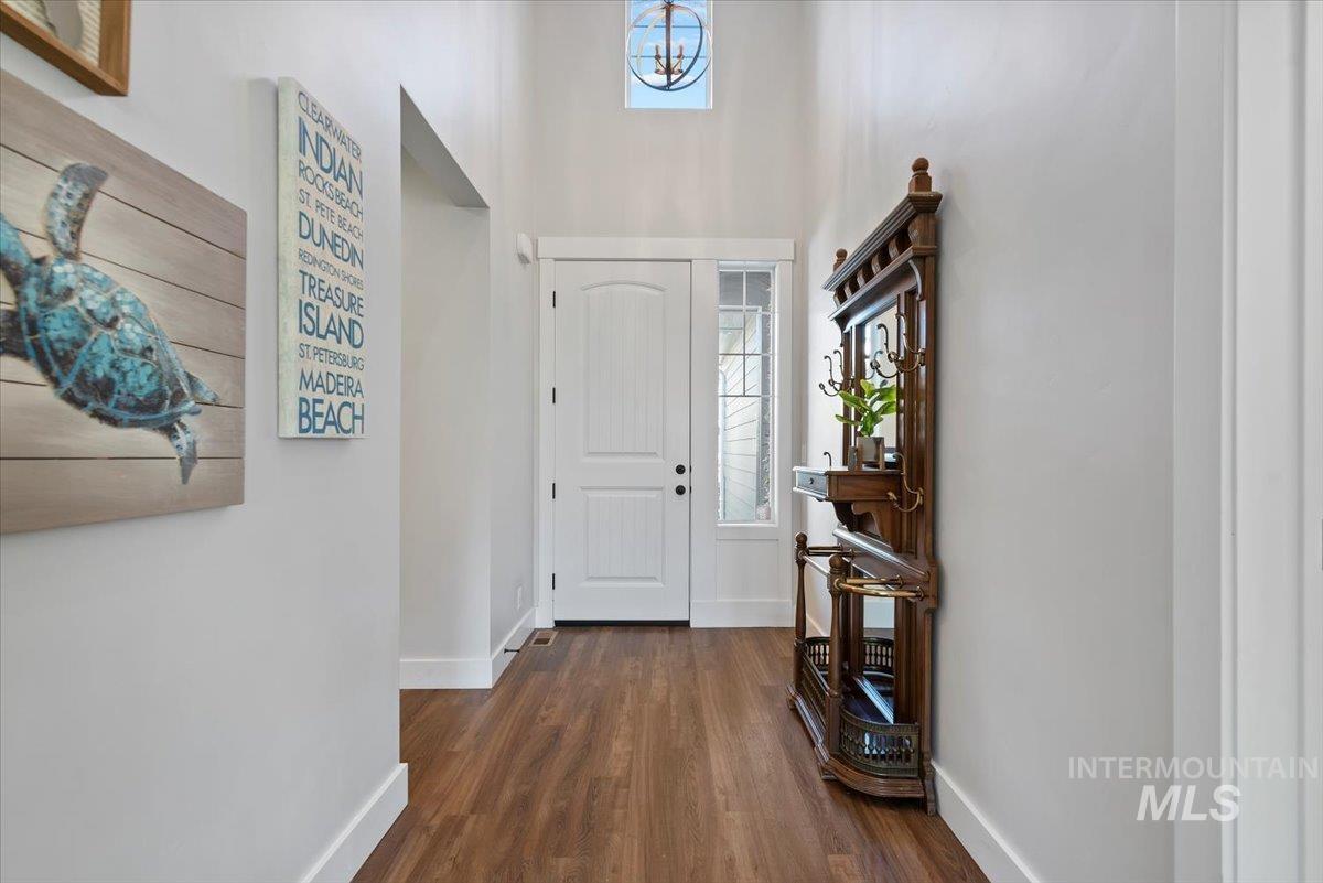 Entrance foyer featuring dark wood-style flooring and a towering ceiling