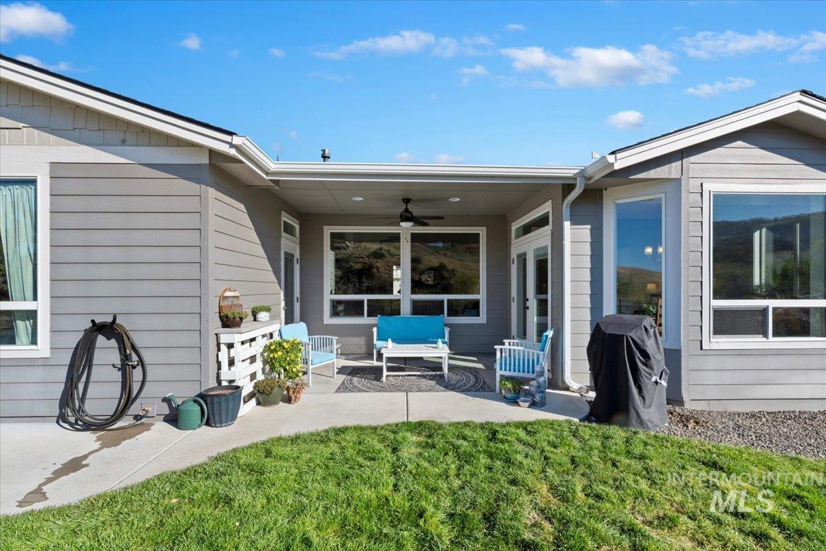 Back of property featuring ceiling fan, outdoor lounge area, a patio, and a yard