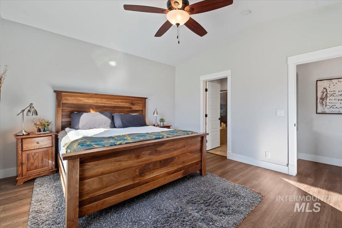 Bedroom featuring wood finished floors, lofted ceiling, and ceiling fan
