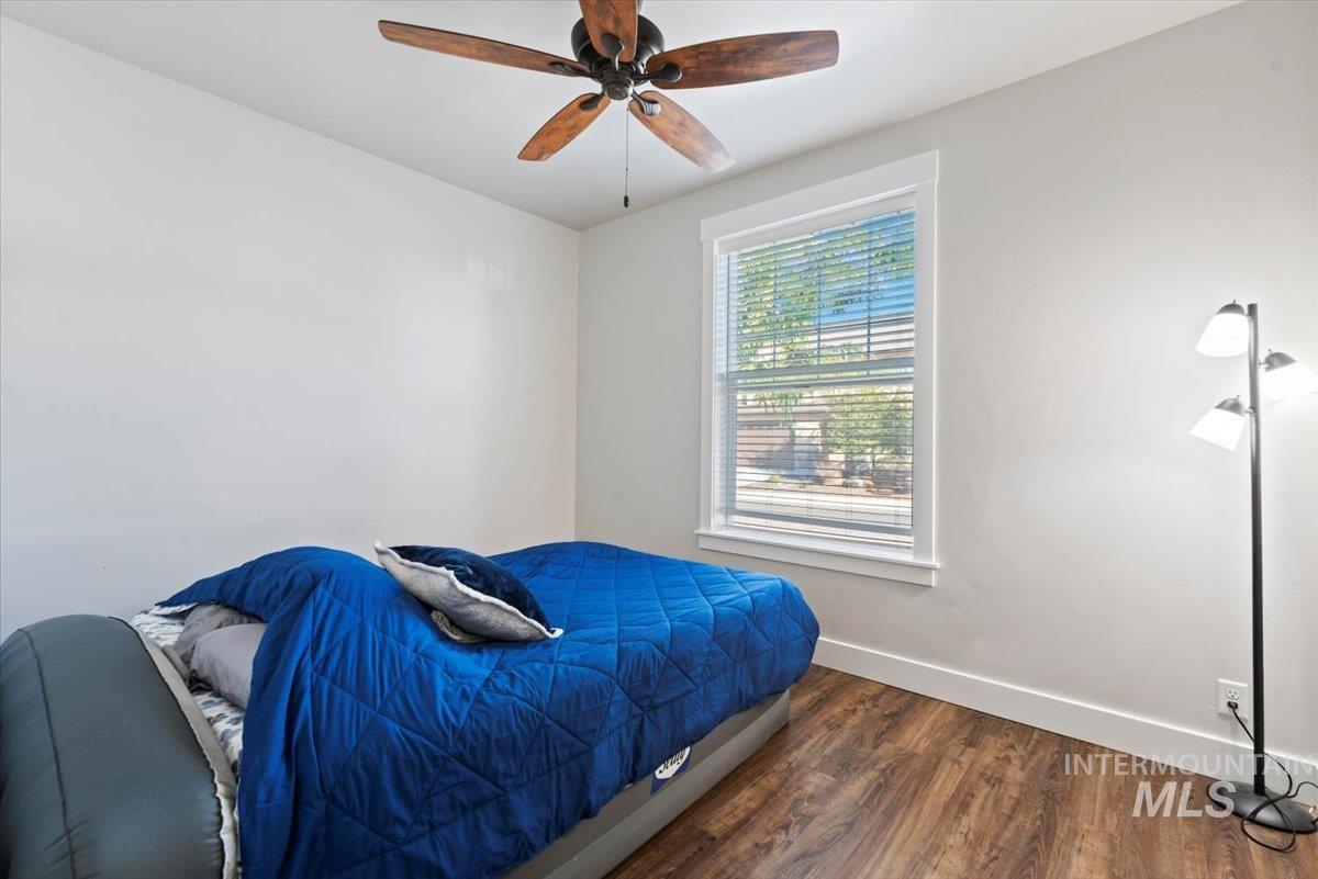 Bedroom with dark wood finished floors and a ceiling fan
