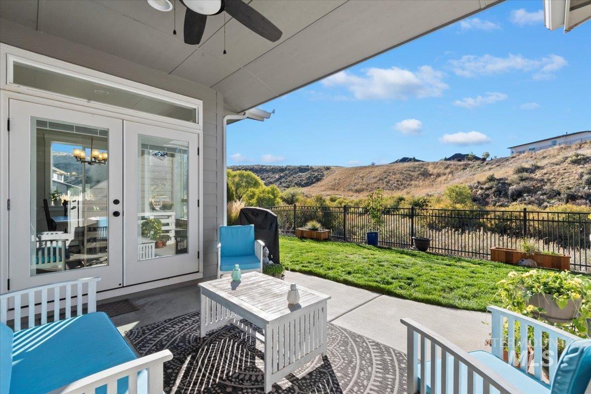 Fenced backyard with a patio, french doors, an outdoor living space, and ceiling fan