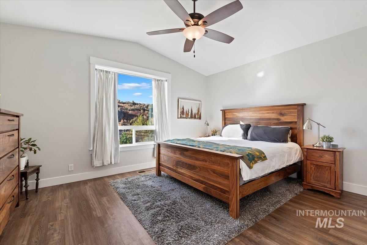 Bedroom featuring lofted ceiling, ceiling fan, and dark wood-type flooring