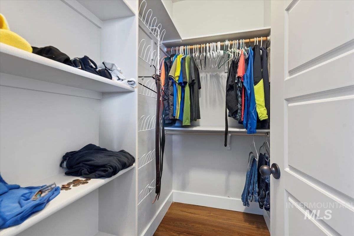 Walk in closet featuring dark wood-type flooring