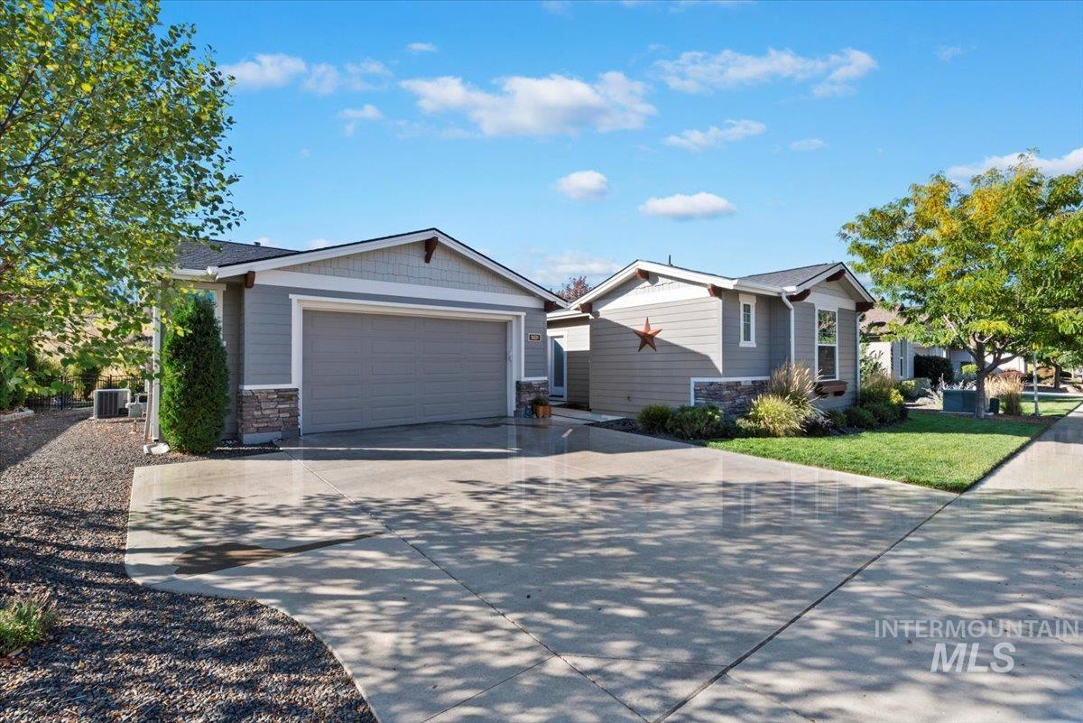 View of front of house with concrete driveway and stone siding