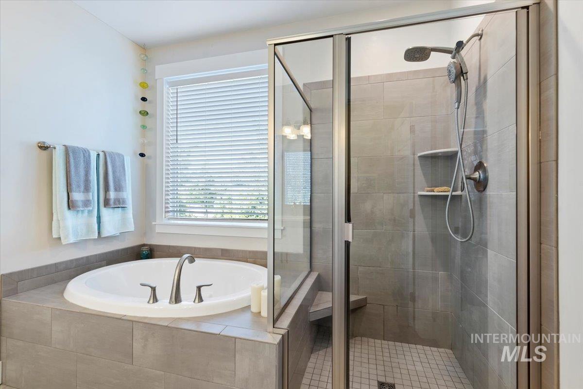 Full bath featuring a garden tub and a stall shower