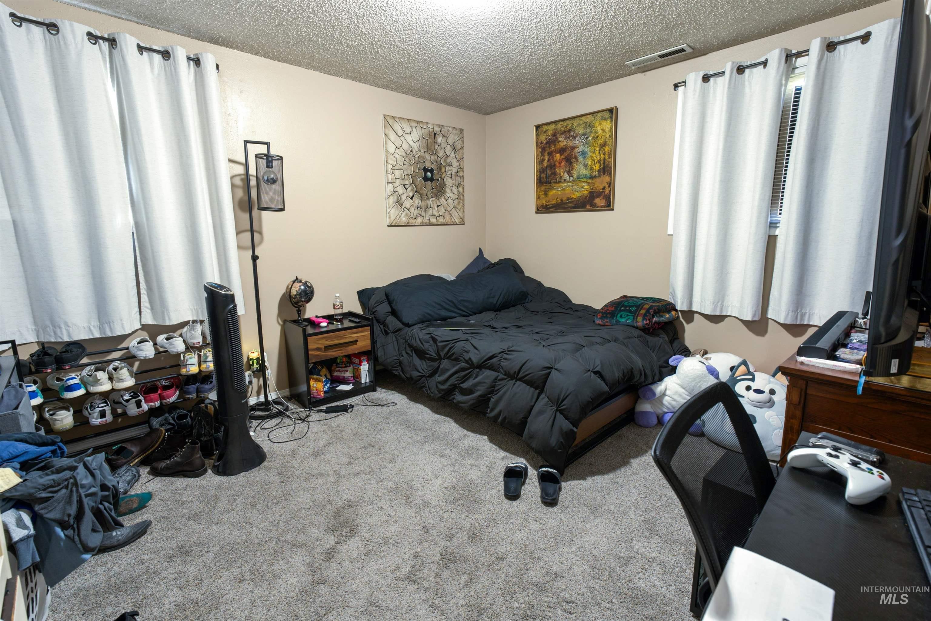 Bedroom featuring textured carpeting and neutral wall paint
