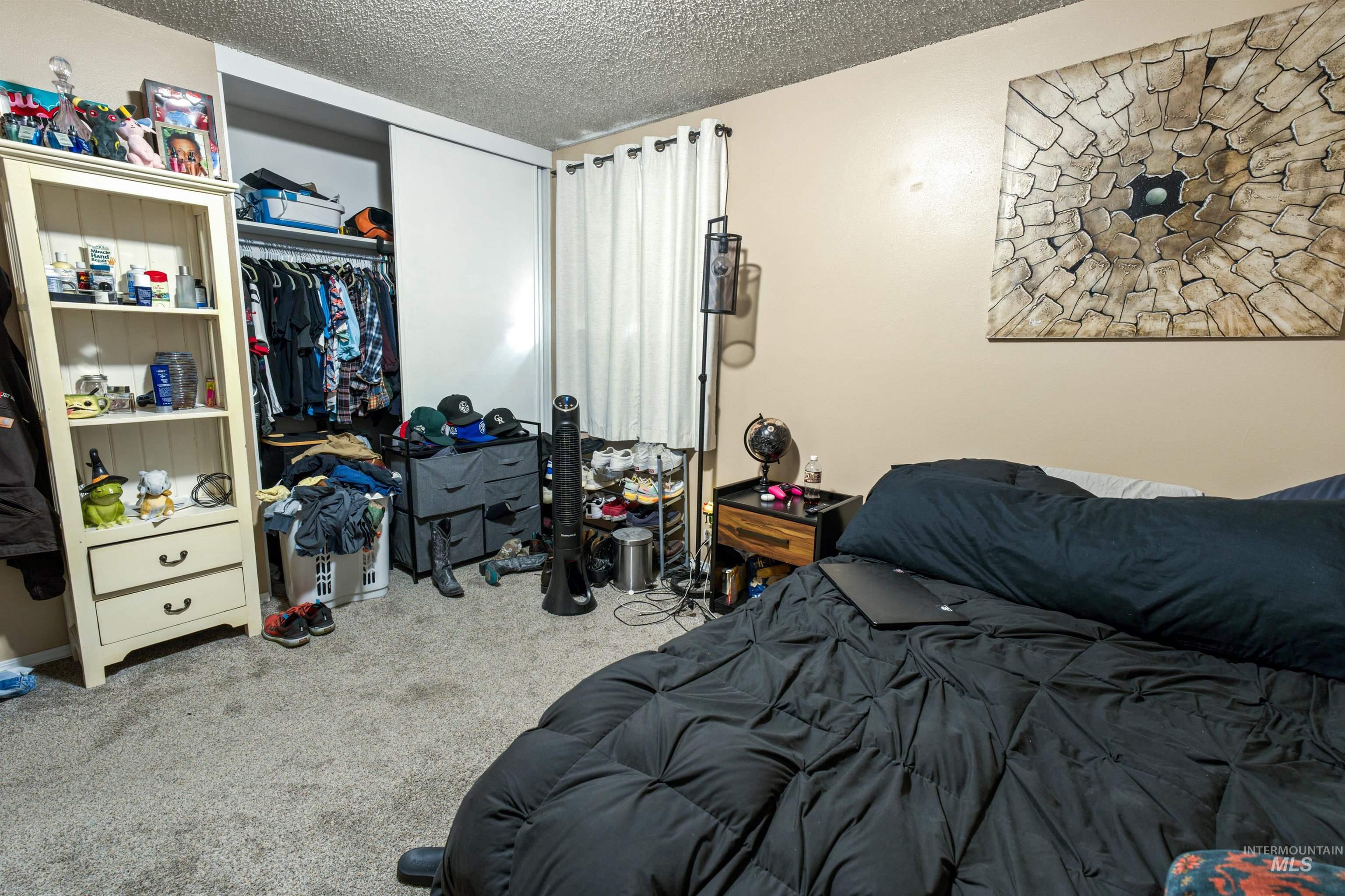 Carpeted room featuring a built-in sliding door closet and neutral wall paint