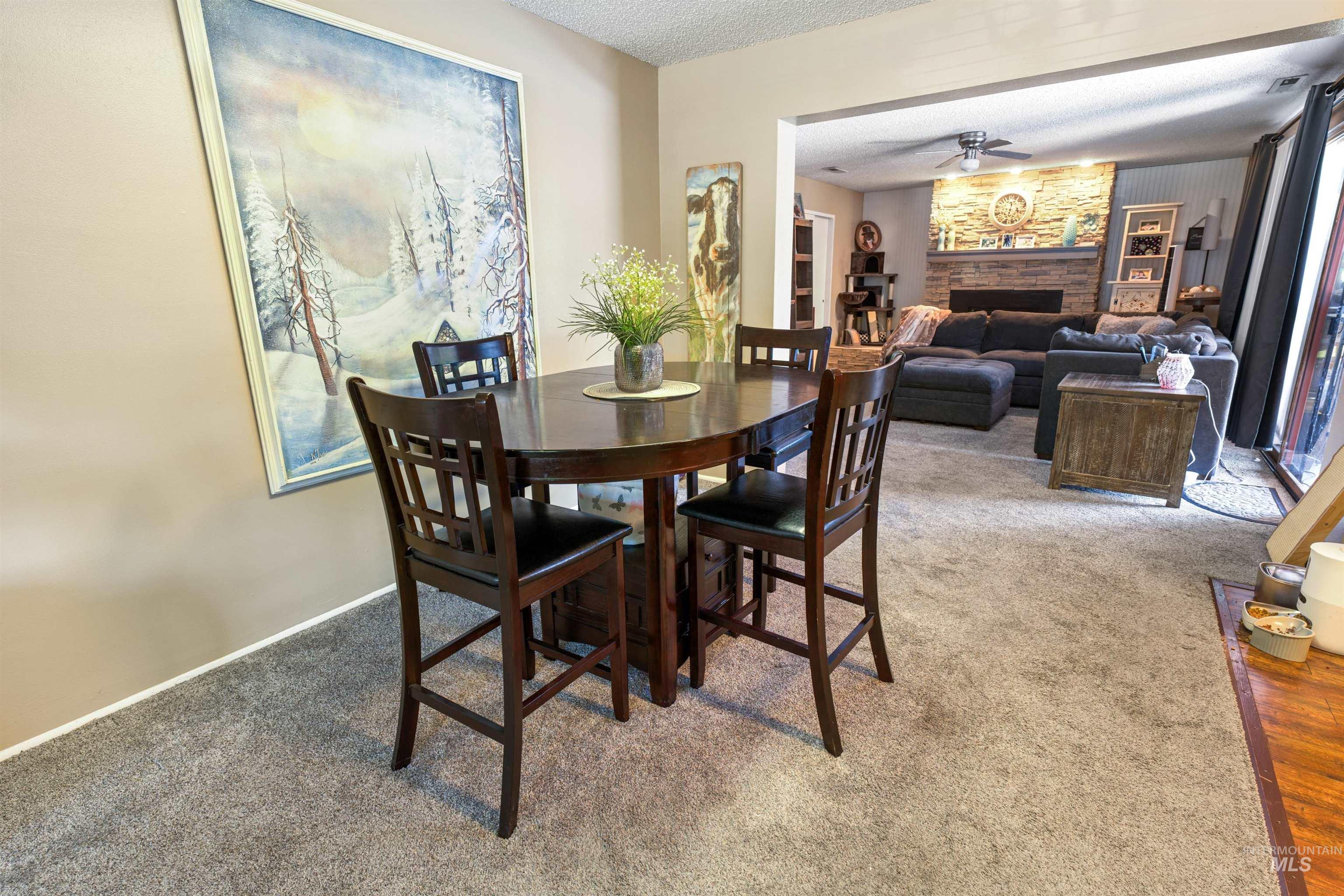 Carpeted flooring throughout the dining area and living room with an open entry to the living space