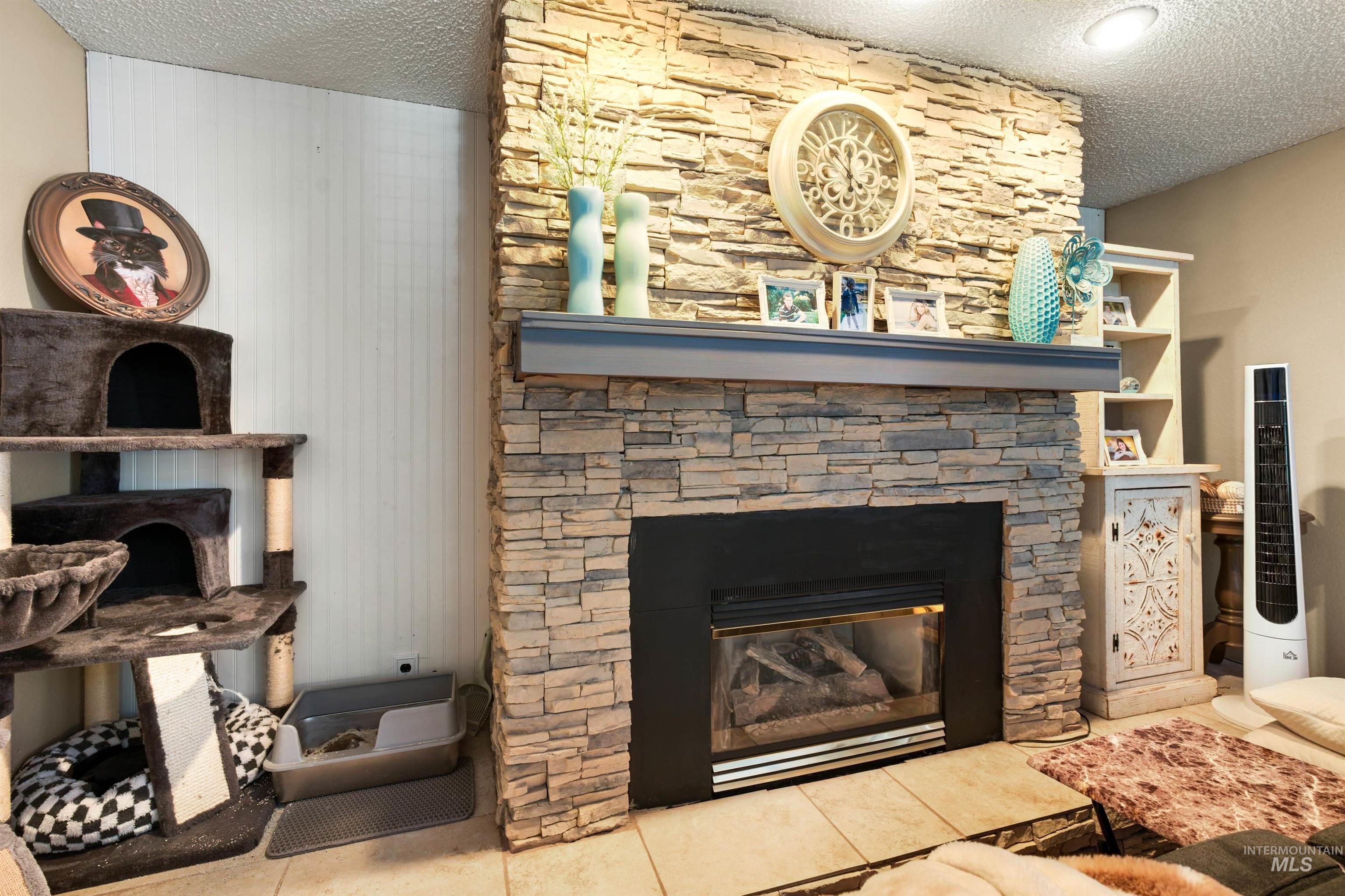 Stacked stone fireplace with a dark mantel and hearth