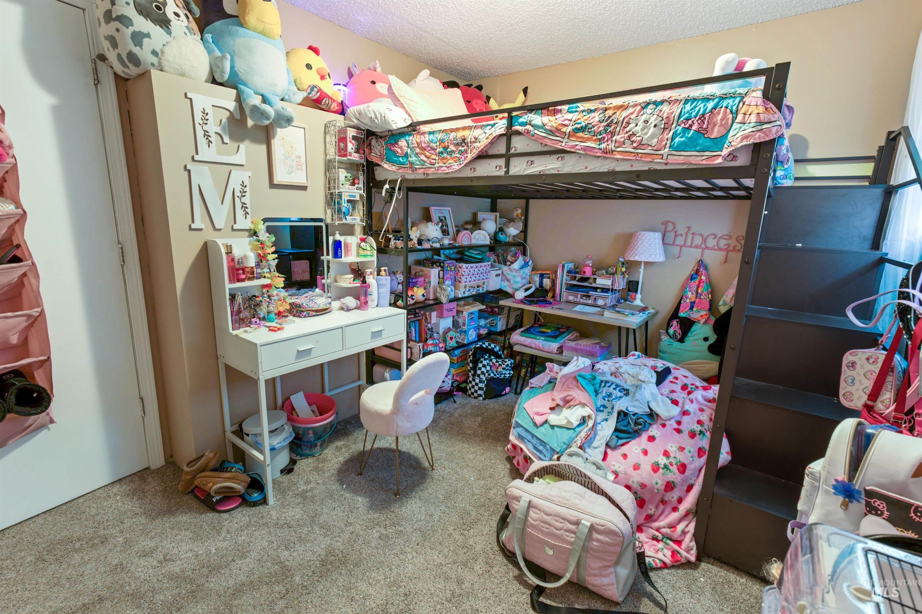 Carpeted room featuring a loft bed structure with integrated stairs and an under-bed desk area