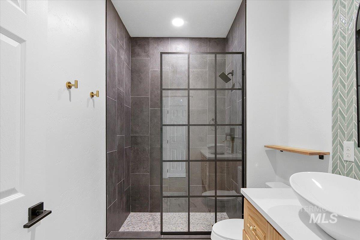 Bathroom featuring a shower stall and vanity