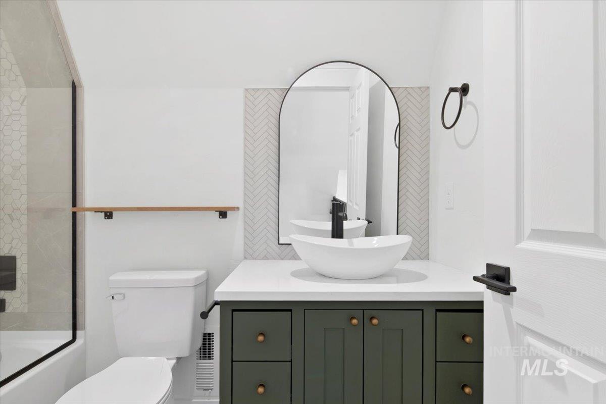 Full bath with vanity and bath / shower combo with glass door