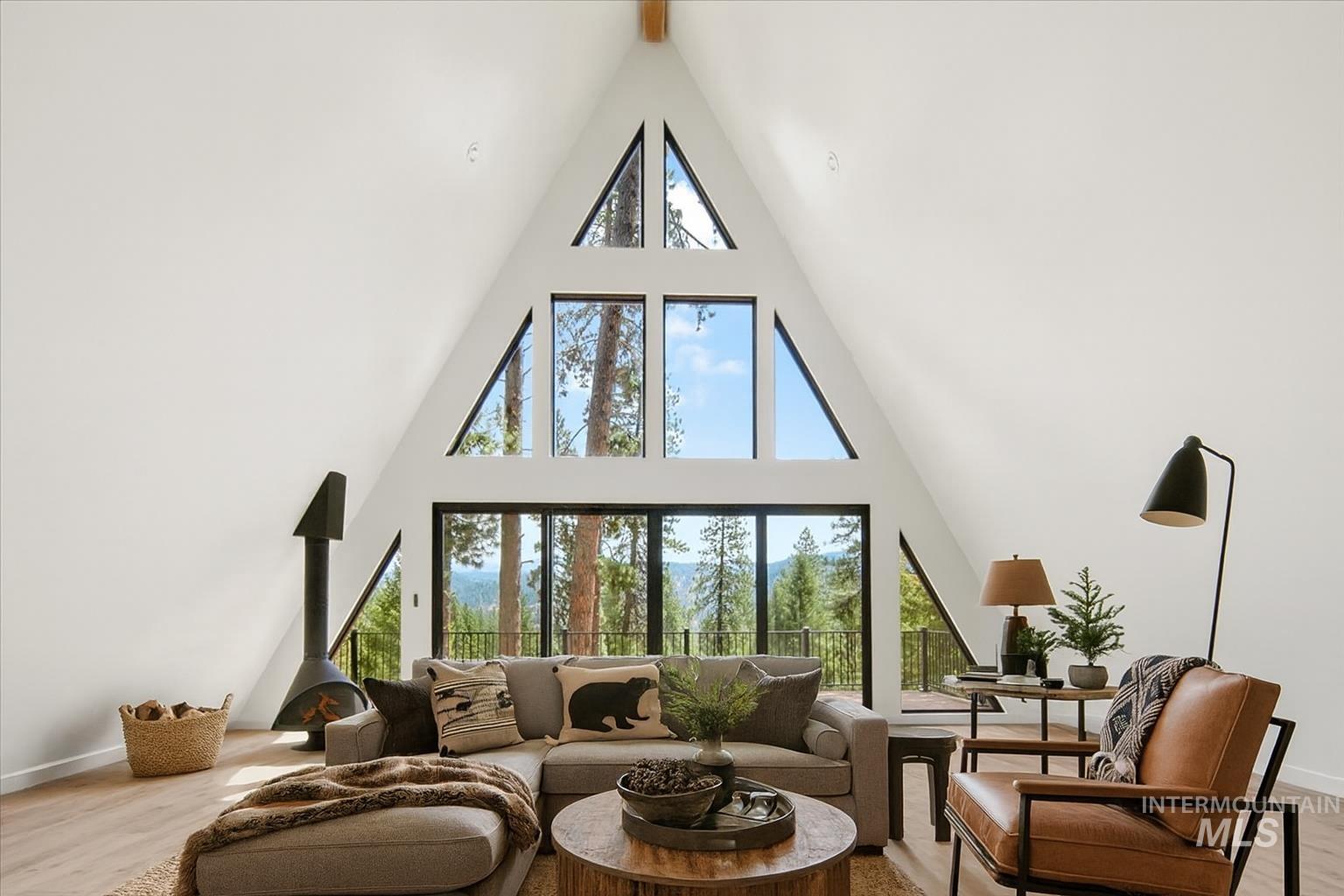 Living room featuring light wood-type flooring, high vaulted ceiling, and beamed ceiling
