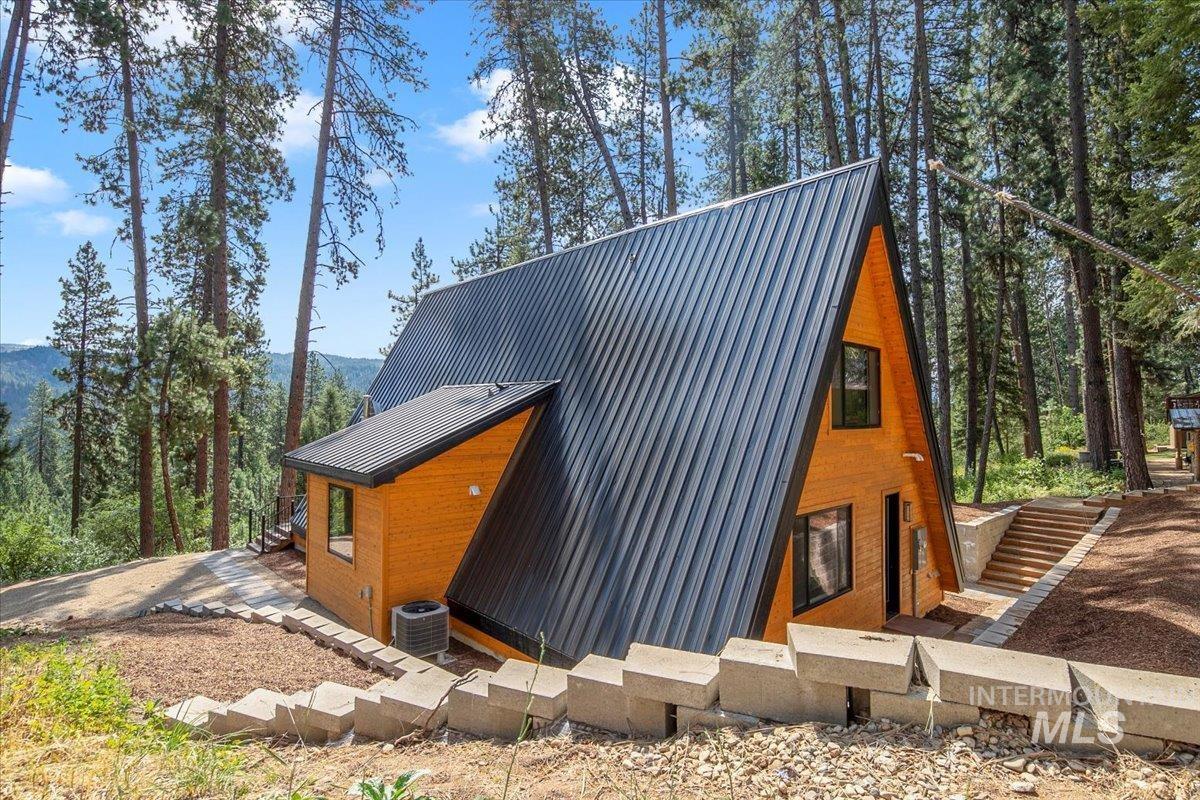 View of home's exterior with a metal roof and a mountain view