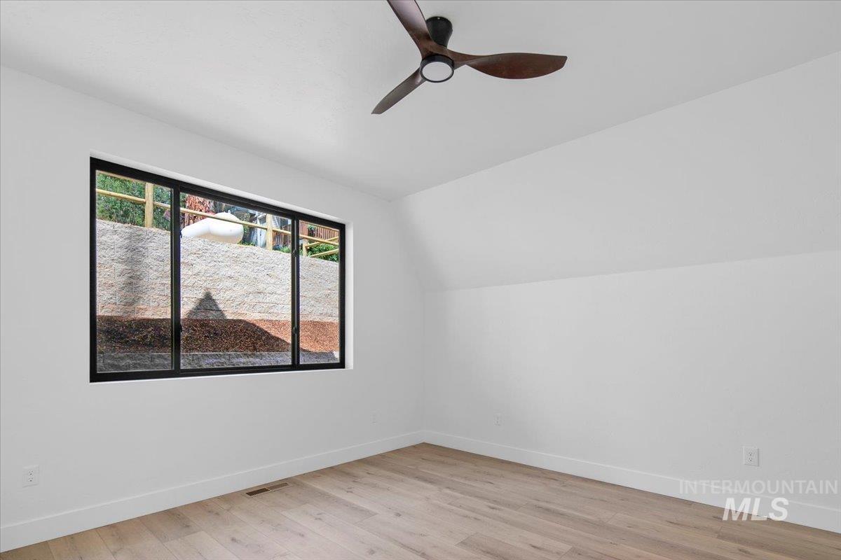 Bedroom featuring lofted ceiling, light wood-type flooring, and ceiling fan