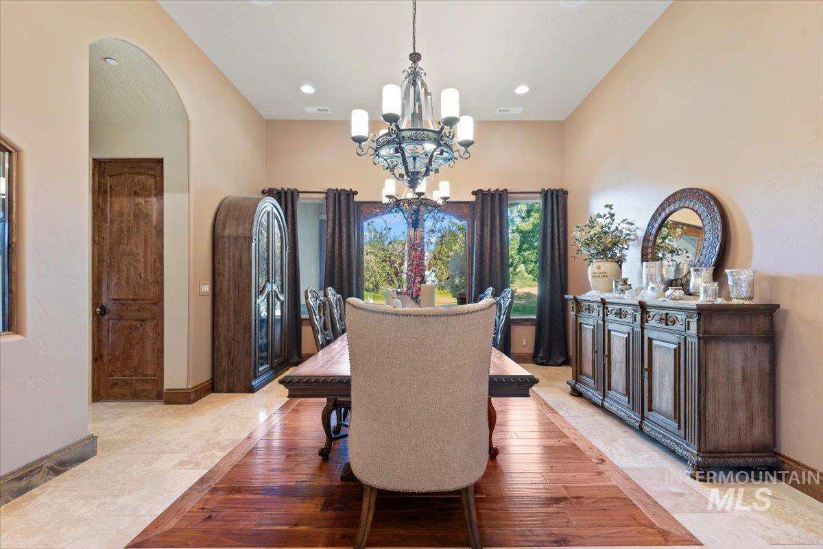 Dining room with a chandelier, arched walkways, and recessed lighting