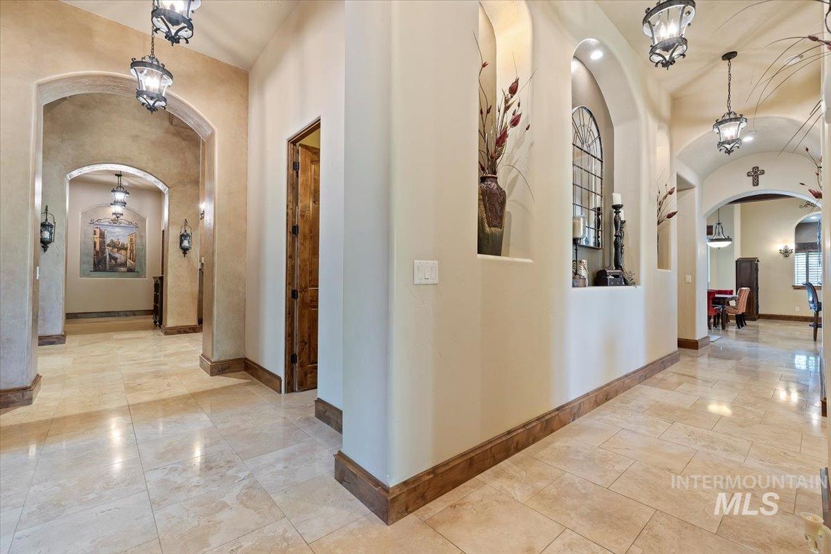 Hallway featuring arched walkways and baseboards