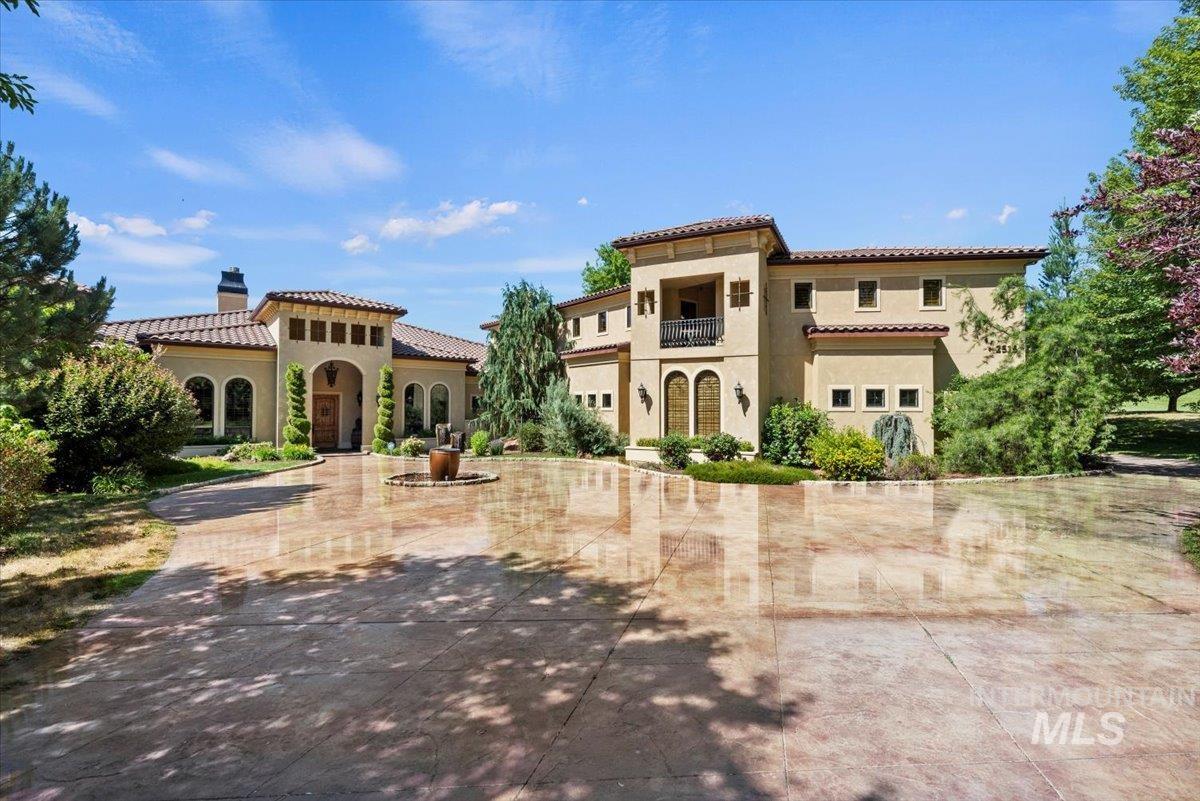Mediterranean / spanish-style house featuring a balcony, a chimney, a tiled roof, and stucco siding