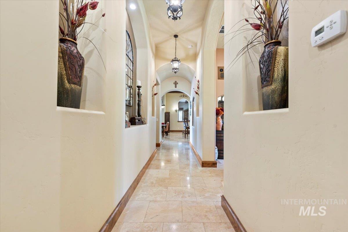 Corridor featuring arched walkways and baseboards