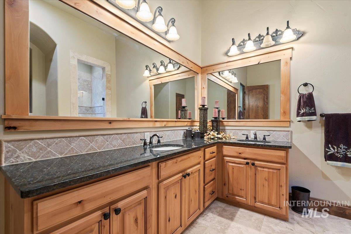 Bathroom featuring double vanity and tasteful backsplash