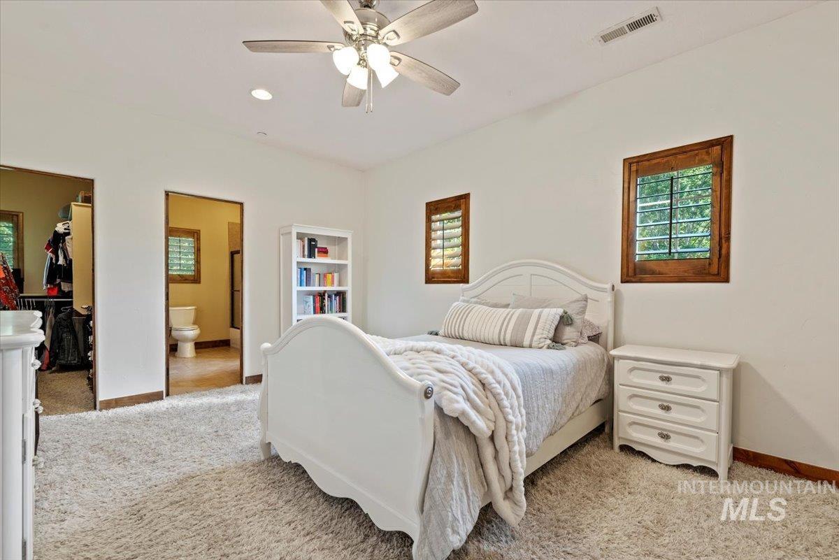 Bedroom with light carpet, multiple windows, and a spacious closet