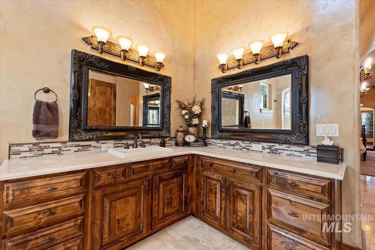 Bathroom featuring decorative backsplash and double vanity