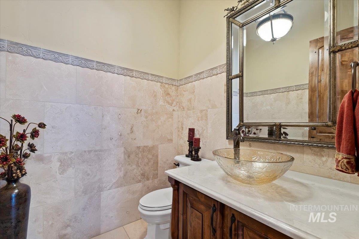 Bathroom with vanity, a wainscoted wall, and tile walls