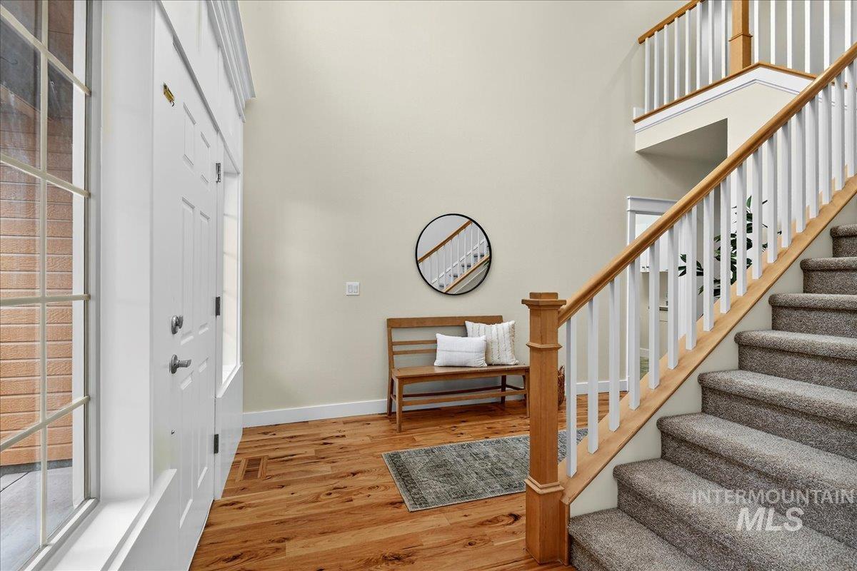 Entrance foyer featuring light wood-style floors, stairs, and a towering ceiling