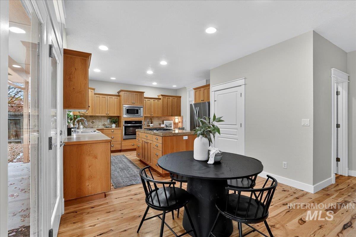 Dining room with light wood-type flooring and recessed lighting
