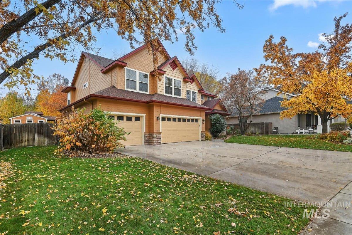 View of front of house featuring stone siding, driveway, and a garage