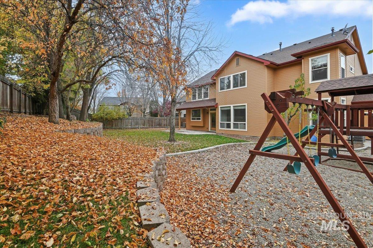 Rear view of house with a playground, a patio, and a fenced backyard