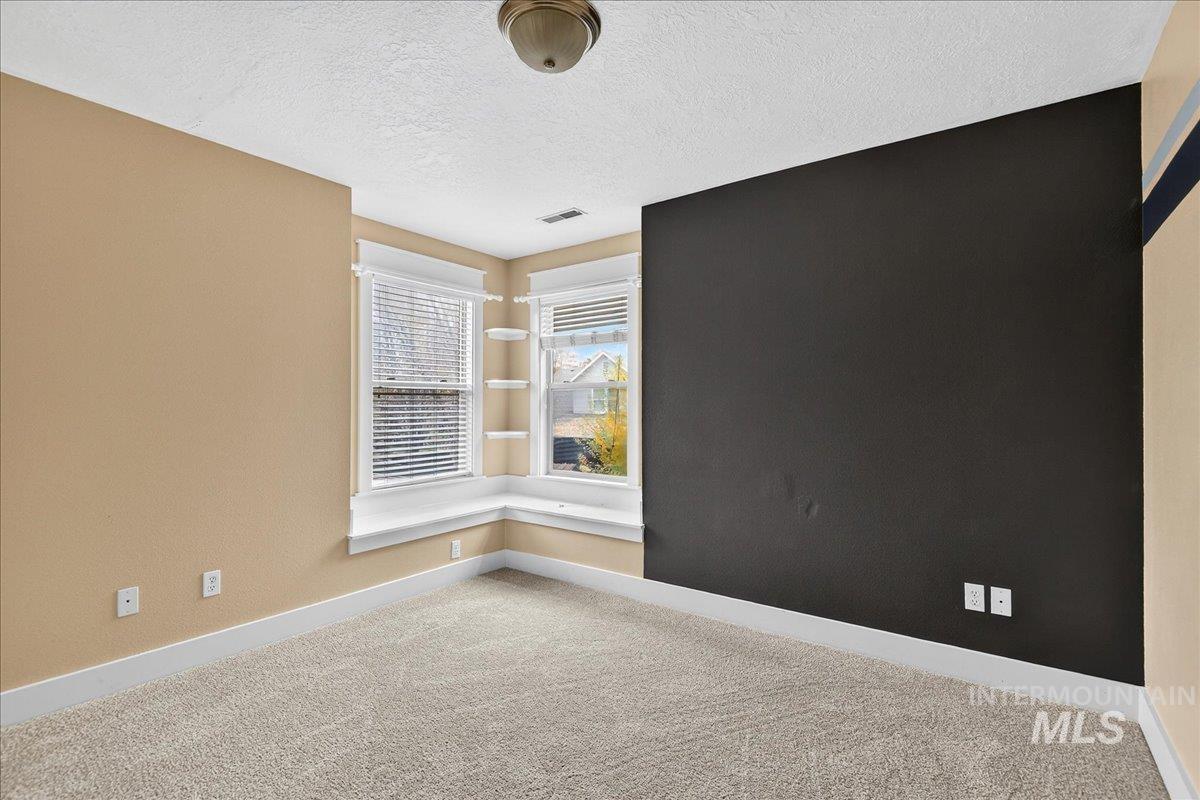 Spare room featuring a textured ceiling and carpet