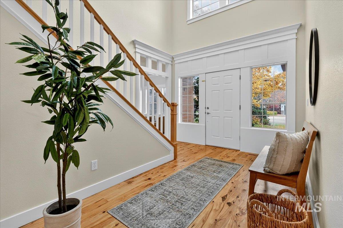 Entrance foyer featuring light wood-style floors, stairway, and a towering ceiling