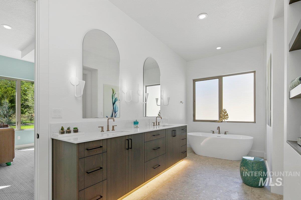 Full bath featuring a freestanding bath, double vanity, and recessed lighting