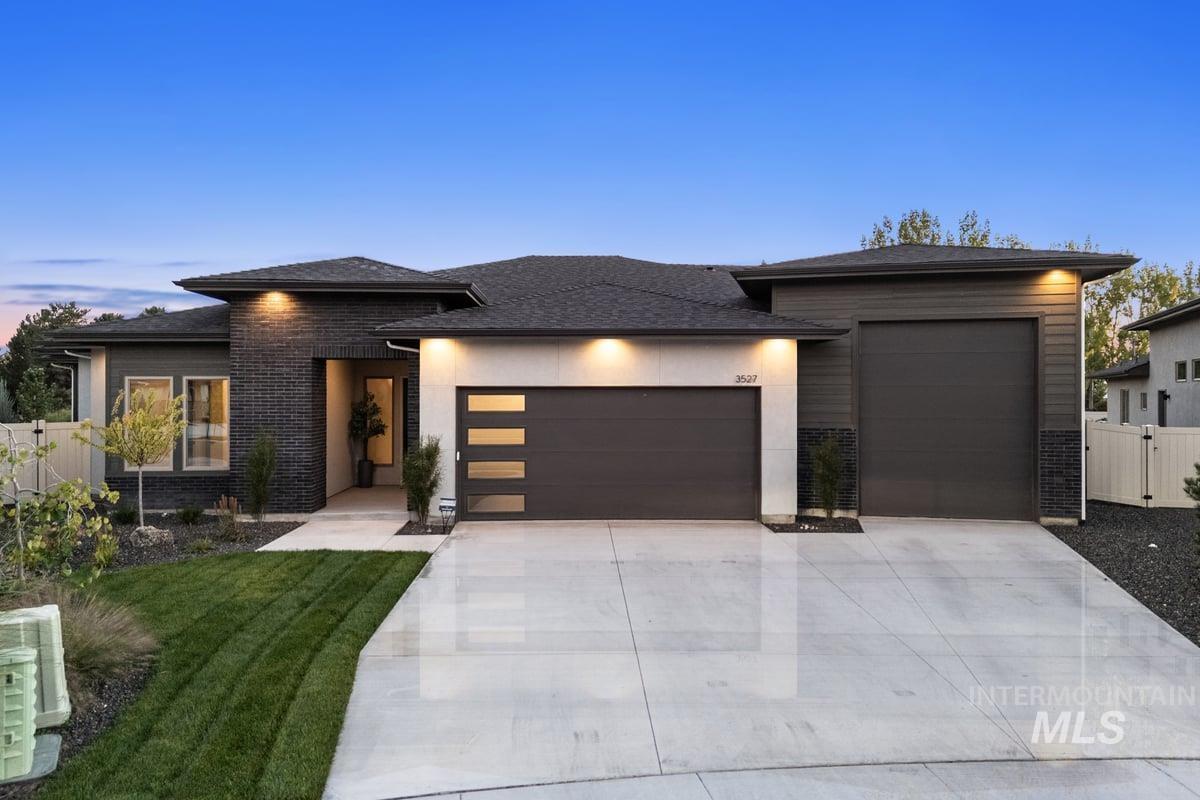 Prairie-style house with a garage, concrete driveway, and a shingled roof