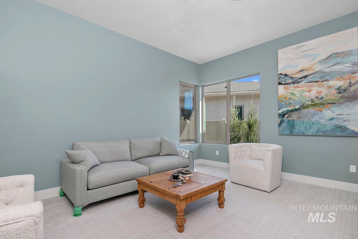 Living area with a textured ceiling and carpet floors