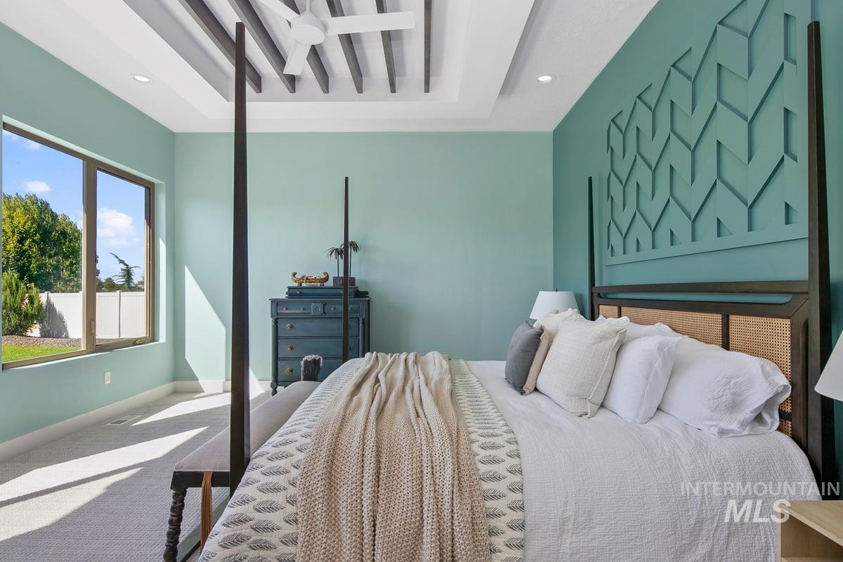 Carpeted bedroom featuring recessed lighting and a tray ceiling