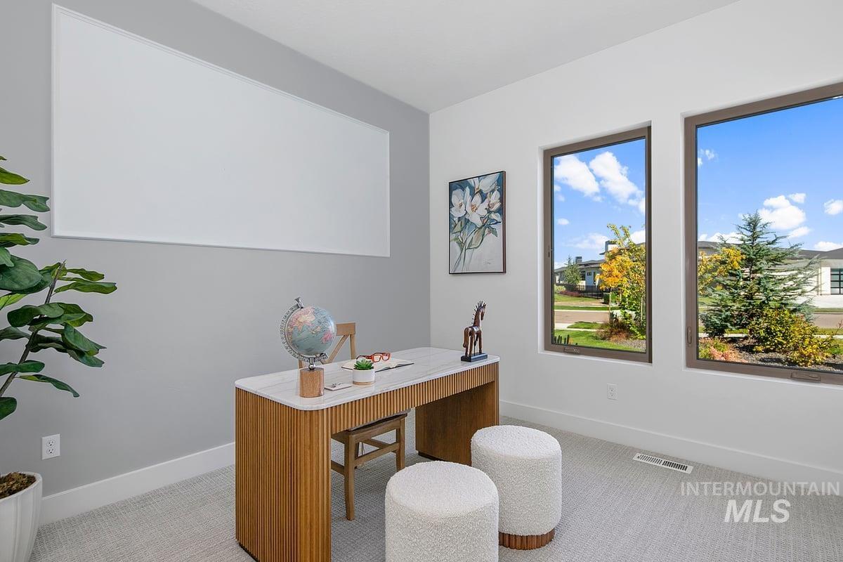 Home office featuring light colored carpet and baseboards