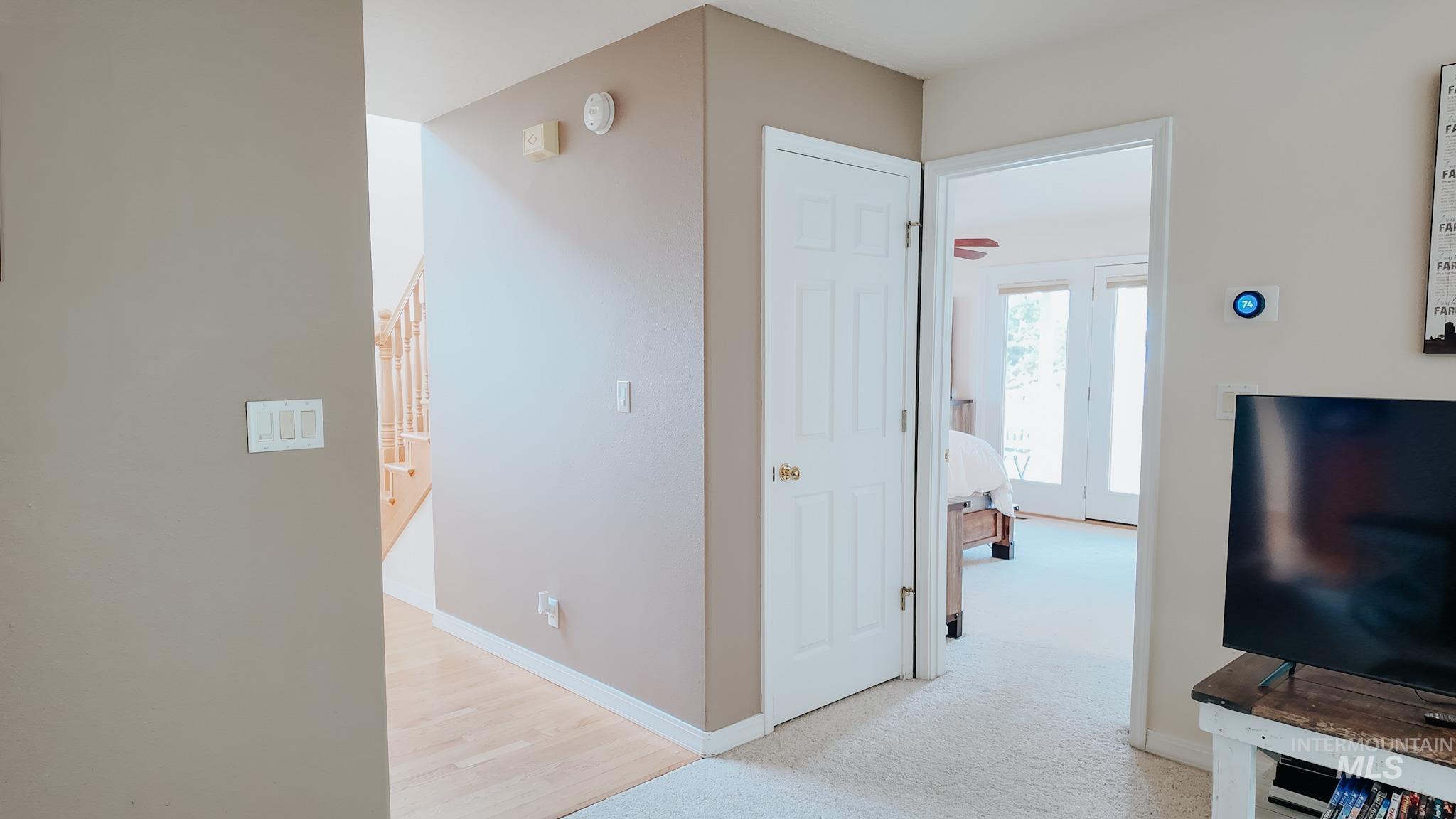 Hallway with light carpet and baseboards